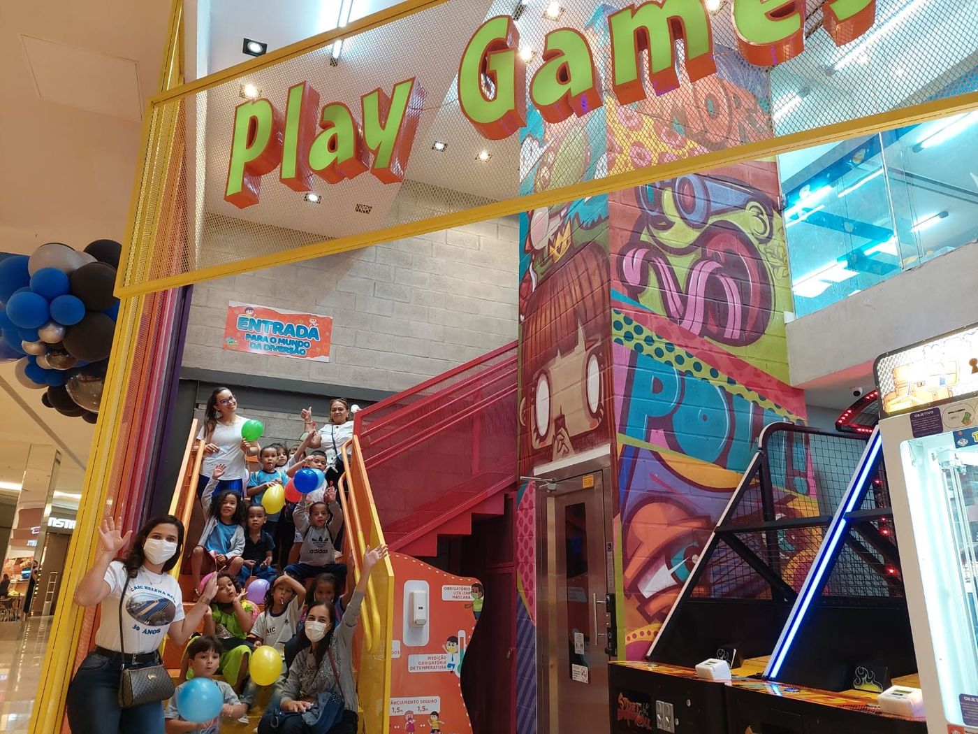 Turma de escola reunida na escada da entrada do Play Games
