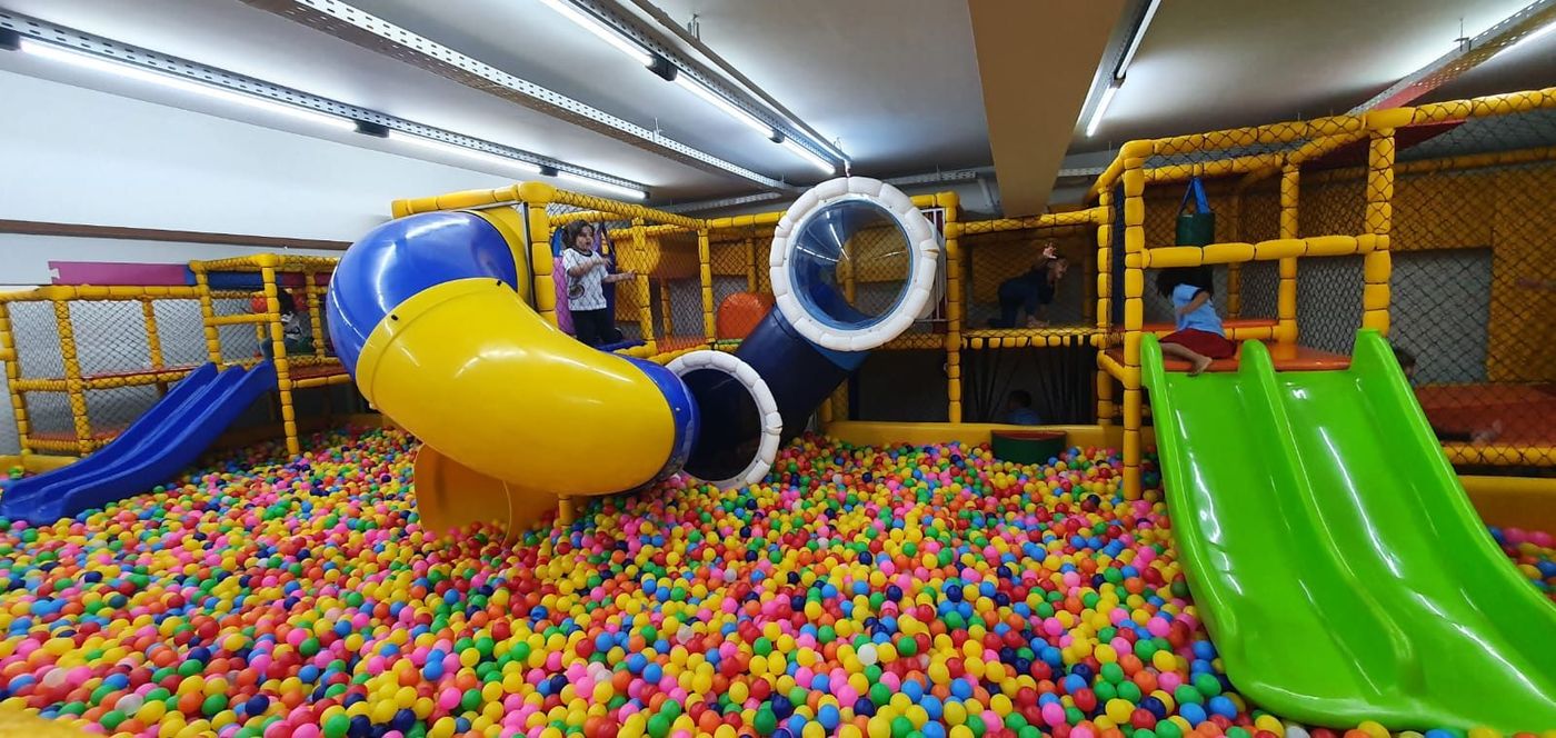 Brinquedão com tubos e escorregadores sobre a piscina de bolinhas
